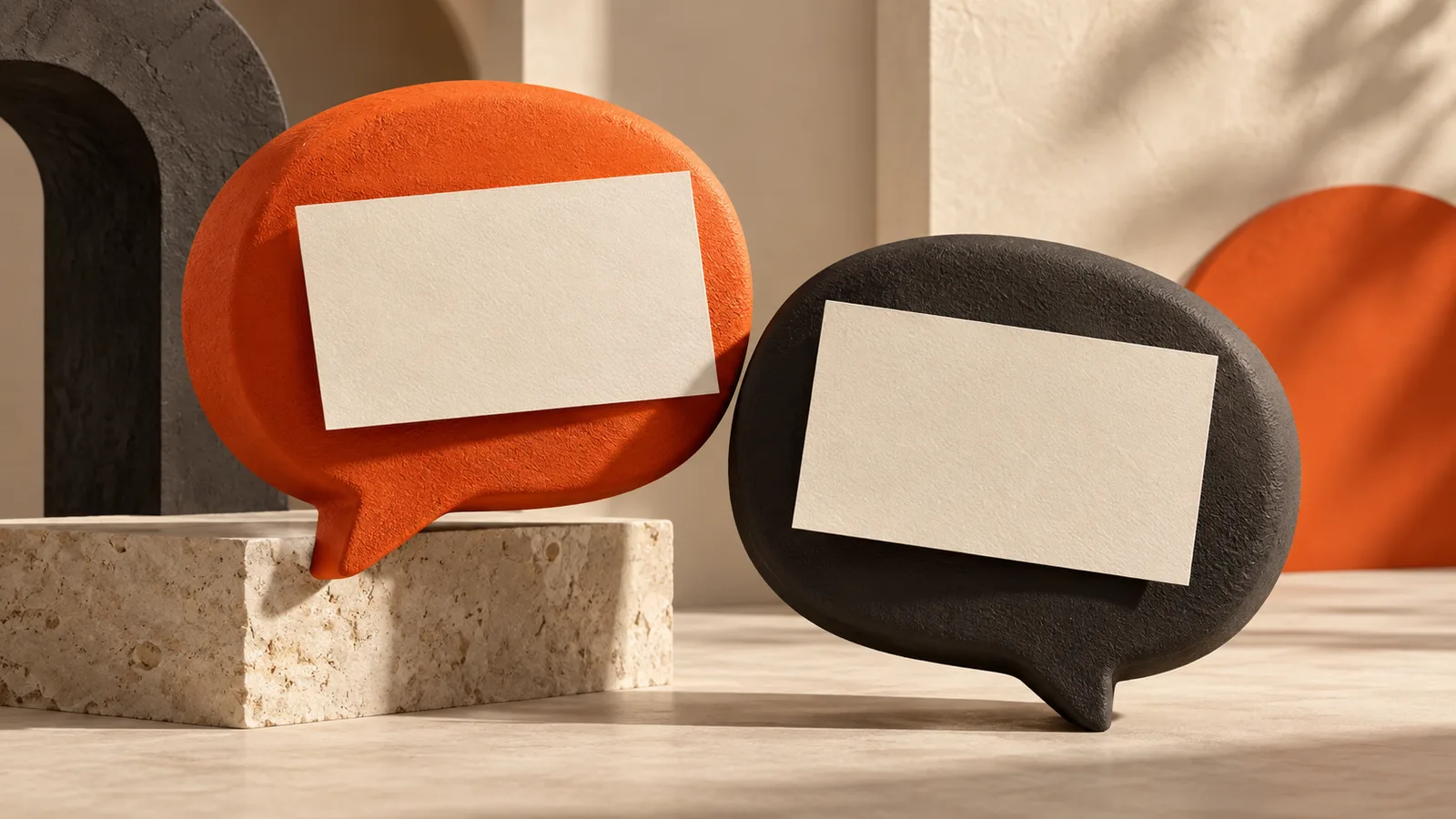 Orange and charcoal speech-bubble sculptures with cream paper cards.